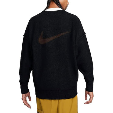 Black sweater with a logo on the back, worn by a person with yellow pants.