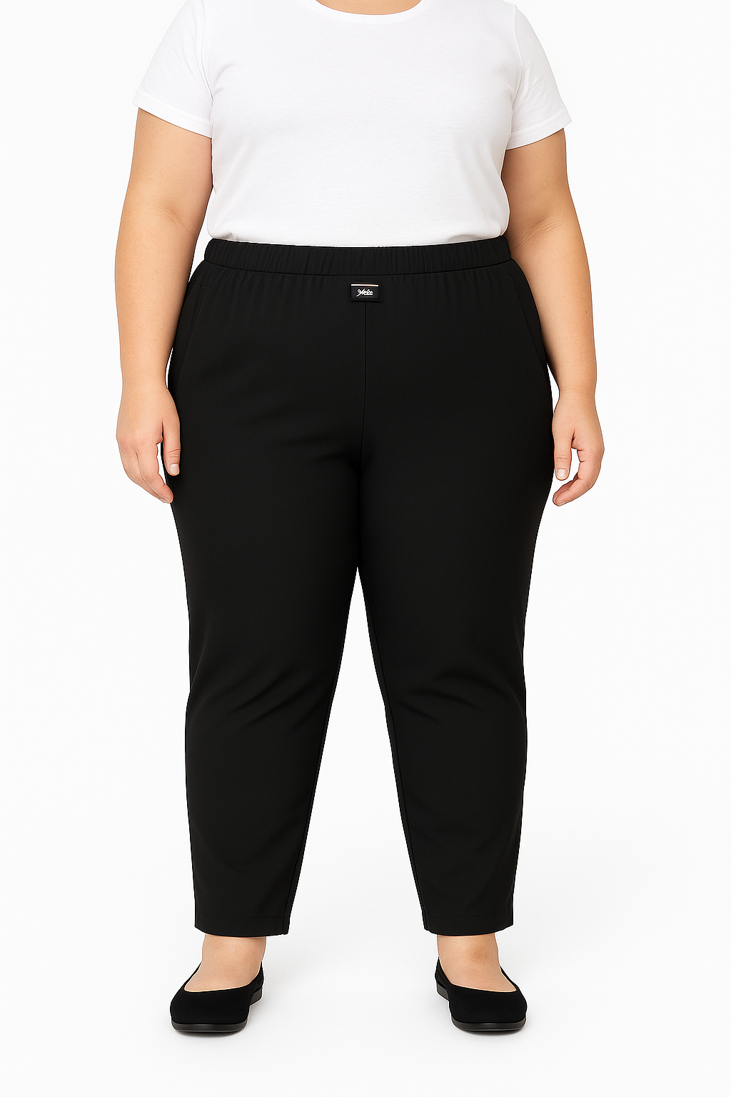 Person wearing black pants and a white top on a plain background