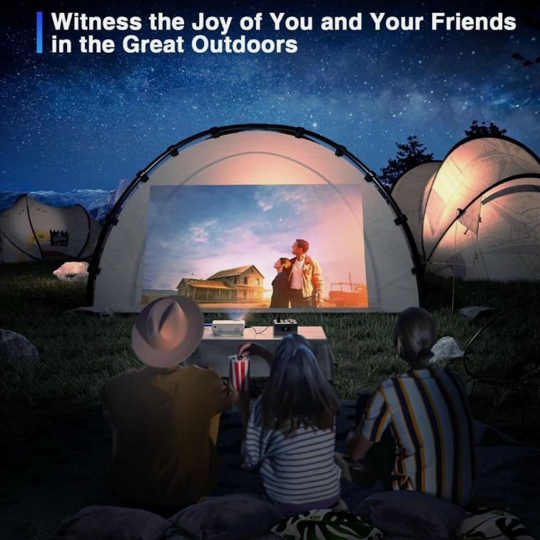 People watching a movie projected onto a screen in a camping setting with tents and a starry sky.