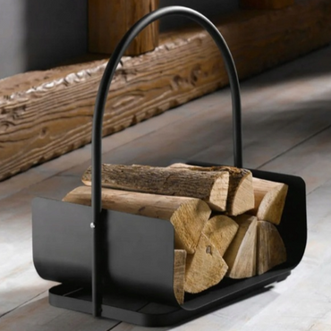 Black metal firewood holder with logs against a wooden background