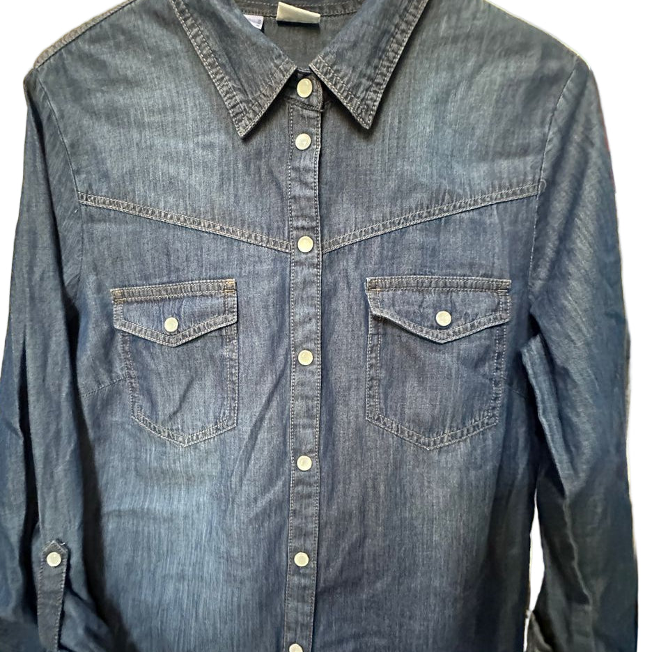 Blue denim shirt on a hanger against a neutral background