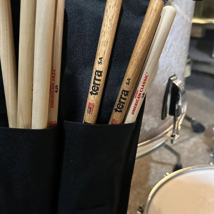Close-up of drumsticks in a Vic Firth holder with a drum in the background