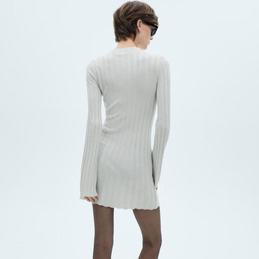 Woman wearing a beige dress on a white background with Mango branding.