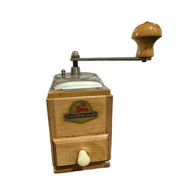 Wooden coffee grinder with Zassenhaus logo on a reflective surface