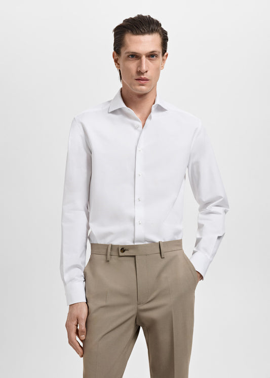 Man wearing a white dress shirt and beige pants on a white background