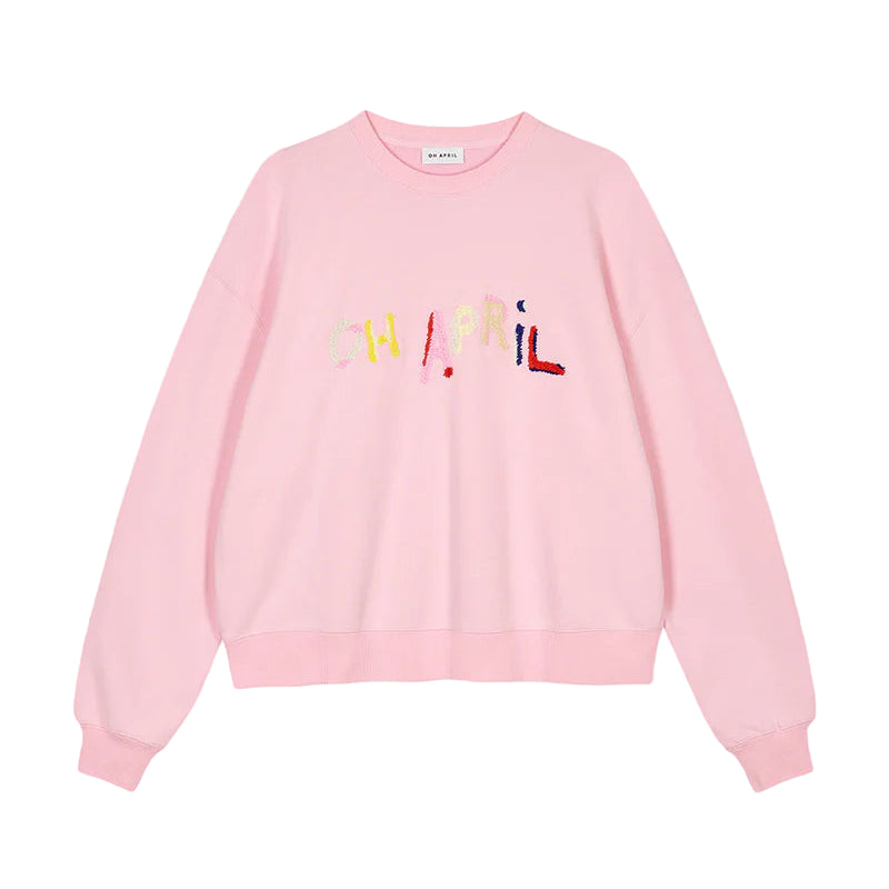 Pink sweatshirt with colorful text on a gray background