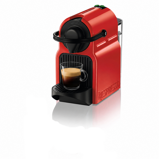 A red and black Nespresso coffee machine with a glass of espresso on its drip tray, shown alongside a purple Nespresso capsule box and three capsules in brown, gold, and purple on a white background.