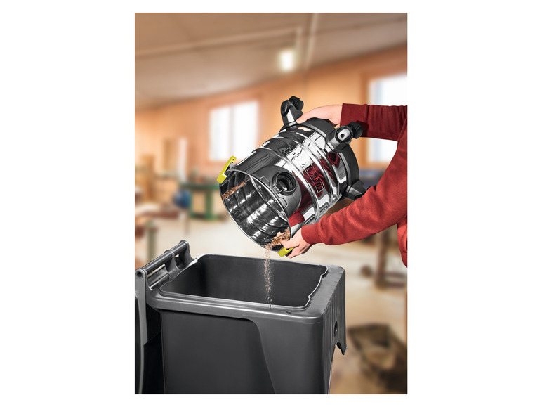 Person using a handheld cleaning device to clean a trash bin indoors.