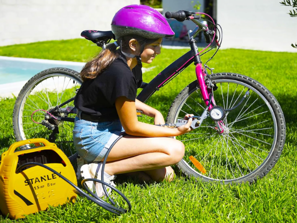 Child with a bicycle and air pump on grass, with text about power and speed.