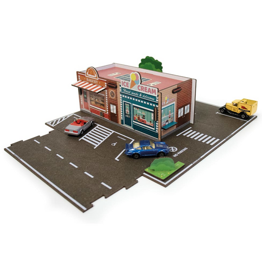Model ice cream shop with toy cars on a miniature road layout