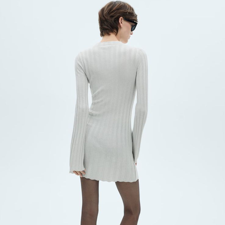 Woman wearing a beige dress on a white background with Mango branding.