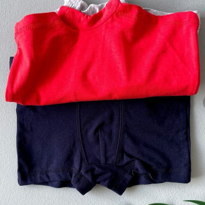 Red shirt and navy shorts on a light gray surface with 'torob.com' in the background.