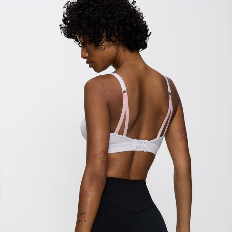 Woman wearing a sports bra and leggings on a white background with Sapo branding.