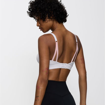 Woman wearing a sports bra and leggings on a white background with Sapo branding.