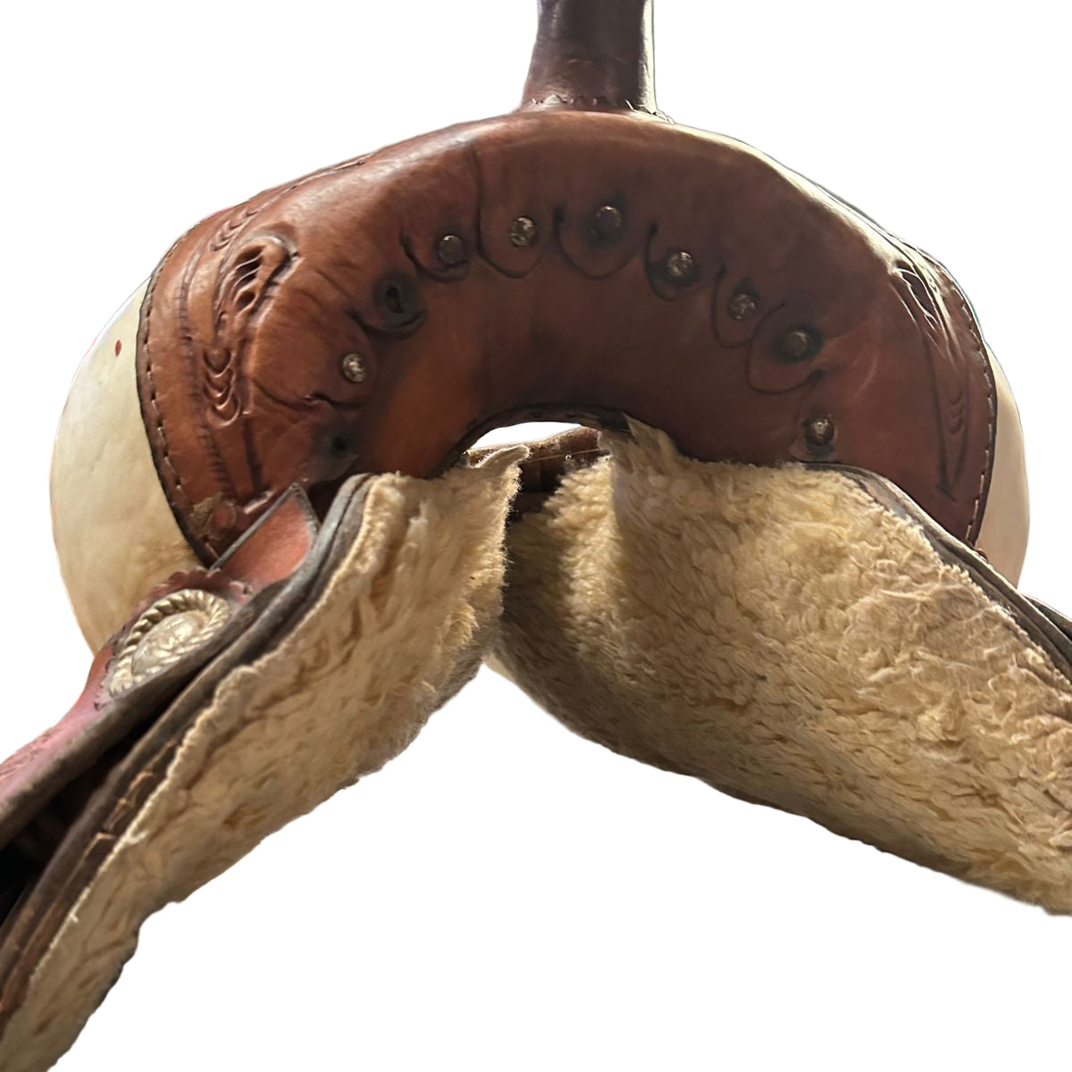 Brown leather saddle on a metal surface with a blurred background