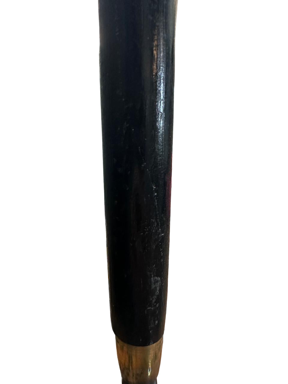 Black cylindrical object on a marble surface with pink bags in the background