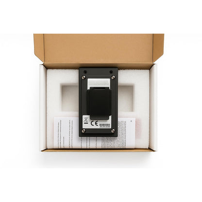 Black electronic device in a cardboard box with white foam padding on a white background