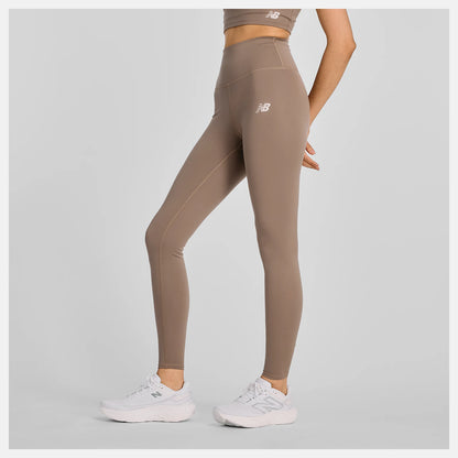 Person wearing brown leggings with a visible brand logo on a gray background